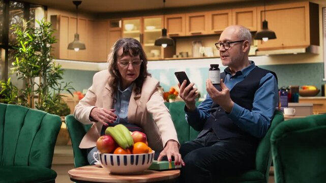 Aged people reading pills box label and online information in living room, prescribed medicine and supplements for in-home routine. Personal care for longevity and healthcare support, recovery.