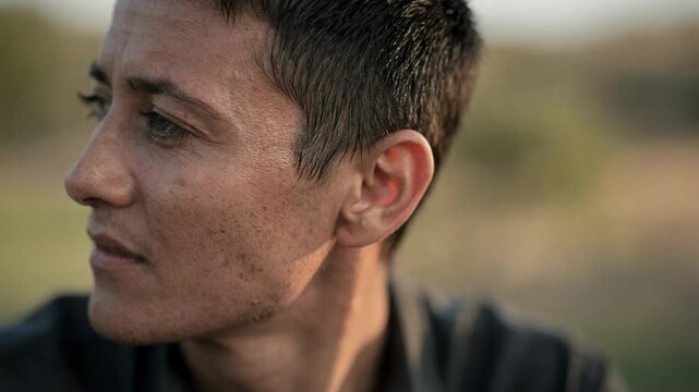 Casual documentary interview outdoors medium frame with focus on the subjects face natural scenery blurred in background creating an intimate and authentic atmosphere.