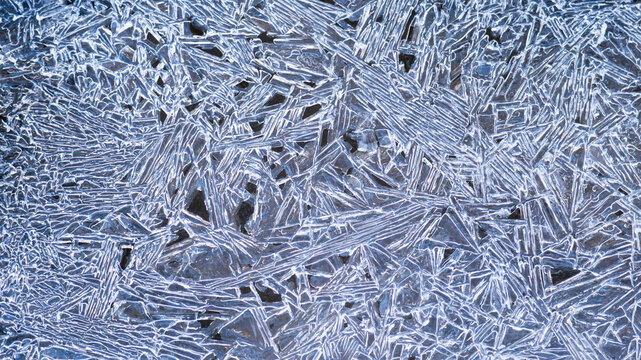 Thin blue shards of ice frozen together in chaotic pattern