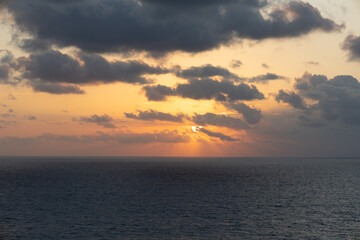 Fototapeta premium Dramatic Caribbean Sunrise with Golden Sky and Dark Clouds Over the Ocean