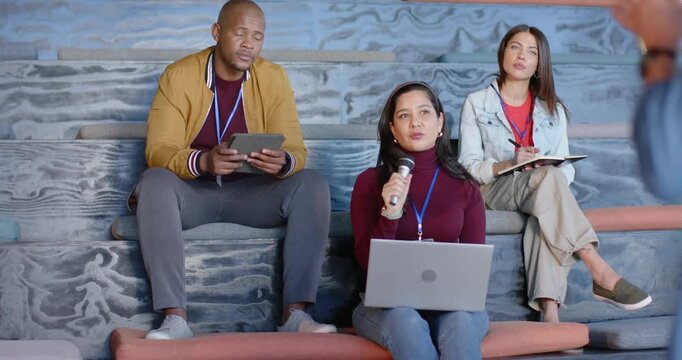 Responding to speaker Diverse panelists leaning posing question into mic in conference hall