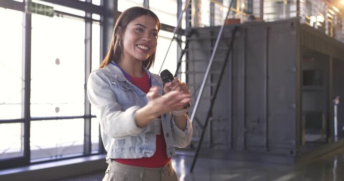 Indian woman holding microphone introducing session, posing question, thanking and bowing in hall