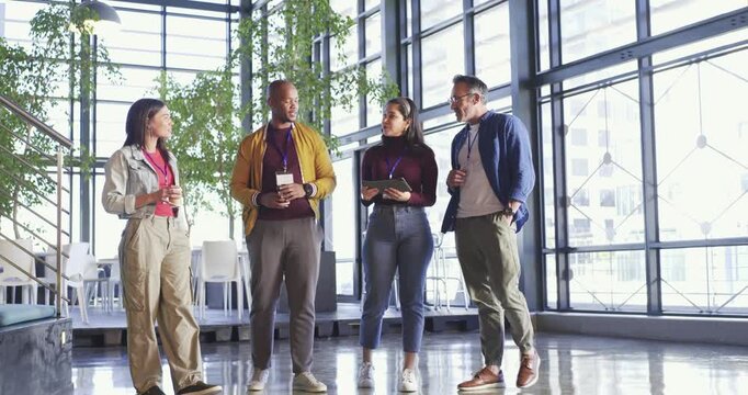 Diverse coworkers entering office atrium holding coffee cup, bumping fists, shaking hands to greet