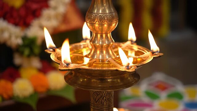 Intricate Golden Oil Lamp With Seven Flames Aglow Illuminating A Vibrant Background Of Flowers And Colorful Rangoli During A Festive Indian Ceremony