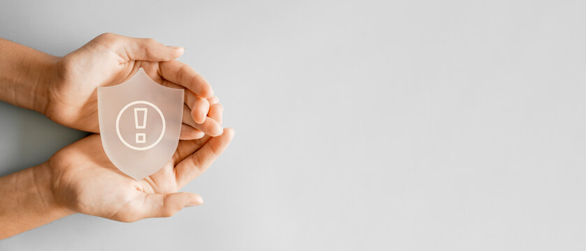 Hands holding transparent shield, business risk management, insurance protection, hazard security concept