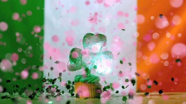 Confetti bursting, shamrocks falling around cupcake, topper catching light, celebrating Ireland