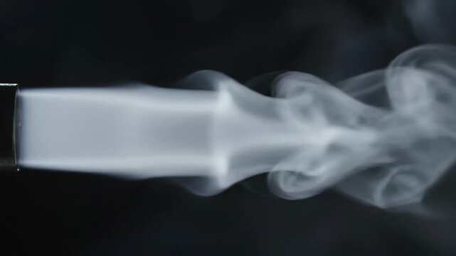 Fluid dynamics: swirling smoke plume ejected from nozzle, turbulent flow visualization