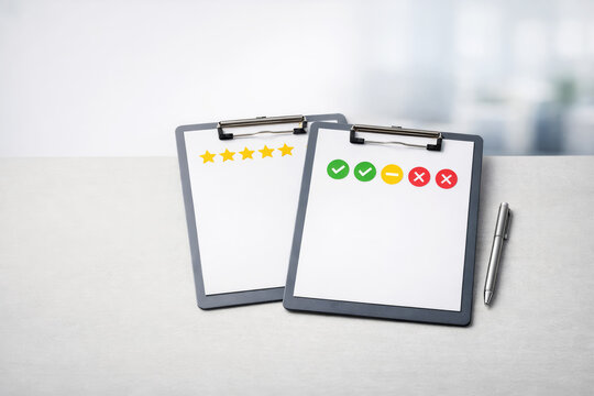 Two clipboards with rating stars and feedback icons on office desk