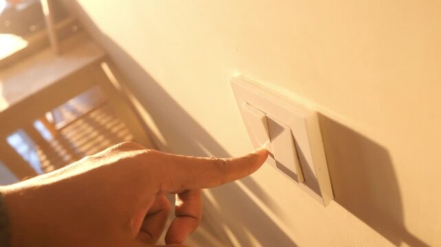Close up video of finger presses light button, hand turns on light switch at home, person turning on light with finger, detail of hand turning on or off on light switch