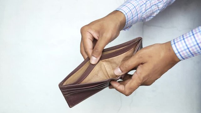 Hands holding and opening empty brown leather wallet showing no money against white background