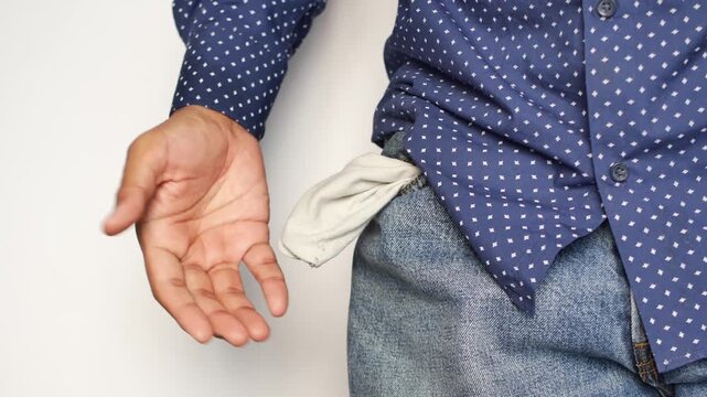 Close up of man showing empty pocket while standing against white background