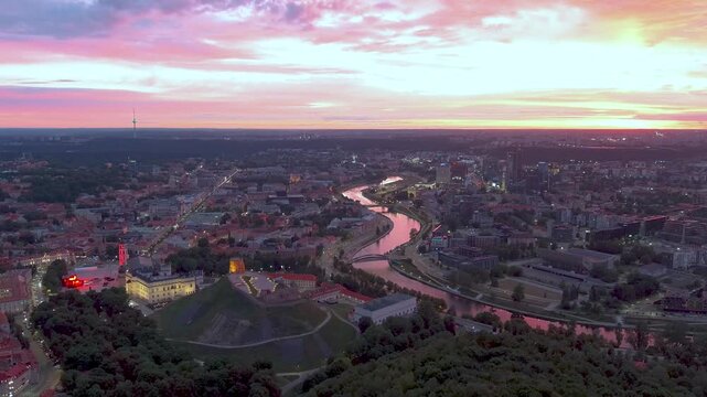 Scenic aerial view of Vilnius Old Town and Neris river at nightfall. Dramatic sunset landscape. Night view of Vilnius, Lithuania.