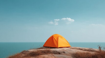Bright orange tent on rocky cliff edge overlooking serene blue ocean under clear sky with few clouds in the distance