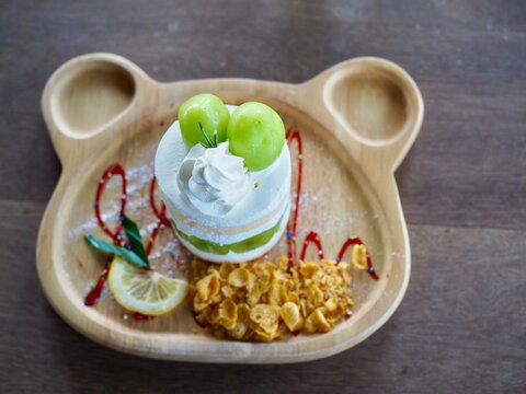 The cake topped with chymus grapes was placed on a wooden tray. It looked delicious and tasted sweet.