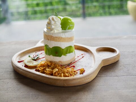 The cake topped with chymus grapes was placed on a wooden tray. It looked delicious and tasted sweet.
