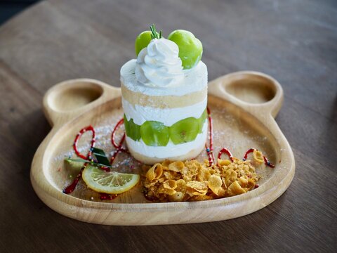 The cake topped with chymus grapes was placed on a wooden tray. It looked delicious and tasted sweet.