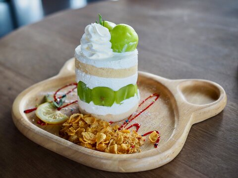 The cake topped with chymus grapes was placed on a wooden tray. It looked delicious and tasted sweet.
