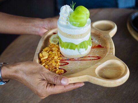 The cake topped with chymus grapes was placed on a wooden tray. It looked delicious and tasted sweet.