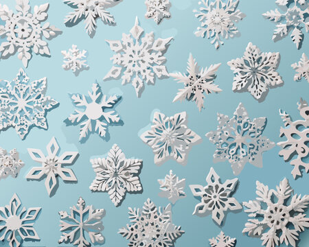 An overhead view of intricately cut paper snowflakes on a blue background