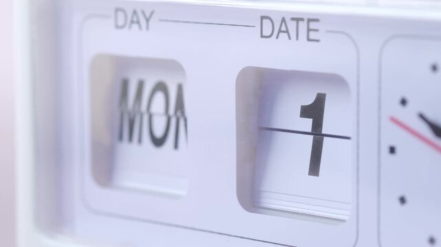 Close-up cinematic video of a flip calendar showing the day changing from monday and the date changing from 30 to 6 in motion