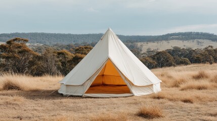 Cozy white bell tent in serene nature landscape with rolling hills and overcast sky, perfect for outdoor adventure getaway