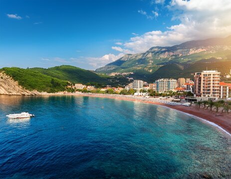 seascape and panorama of a resort town with a beach hotels and boats petrovac montenegro mountains and sunlight