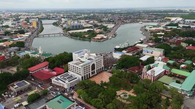 aerial drone cityscape of Iloilo City downtown area, capturing the lush central park and the iconic river 