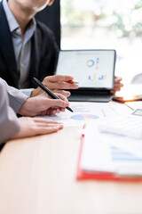 Close-up of business team analyzing financial growth charts and data reports on office desk during...