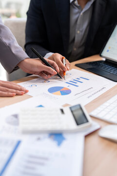 Professional business team analyzing financial growth charts and data reports on office desk during meeting.