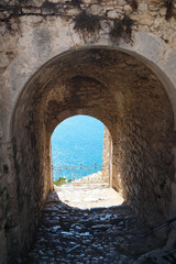 Obraz premium a view through the arch of the turquoise sea and the sun's glare on its surface