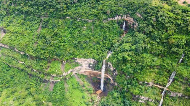 Aerial view of vibrant green landscape with cascading waterfall