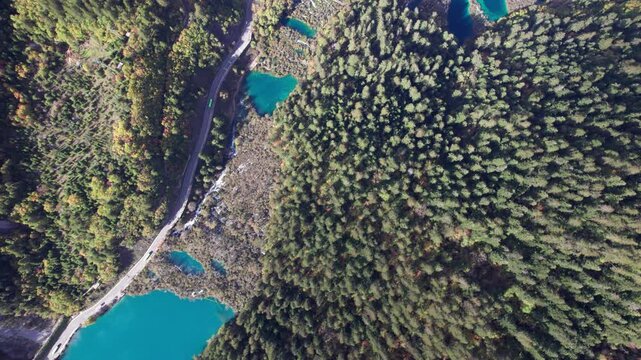 Drone view of Jiuzhaigou National Park in autumn in Sichuan Province China. It features cascading waterfalls, turquoise blue lakes, and stunning mountain valleys. 4K real time footage travel concept