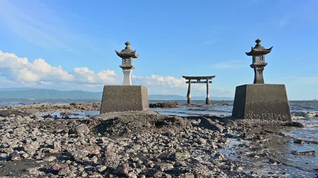 干潮時にだけ歩いて渡れる、神秘の海中鳥居。
「海に眠る祈りの道。干潟に佇む鳥居と灯籠の静寂。」
（宇城市不知火町：永尾剱神社)
"A path of prayer sleeping in the sea. The tranquility of the torii gate and lanterns standing on the tidal flats."
