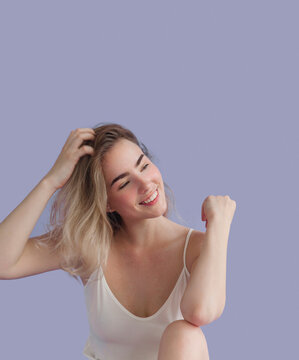 Young beautiful blond woman wearing sexy lingerie like white sleeveless dress looking confident fresh and lovely Fashion model studio portrait on purple background Soft romantic look