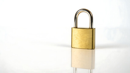 A close-up view of a shiny gold-colored padlock on a white background