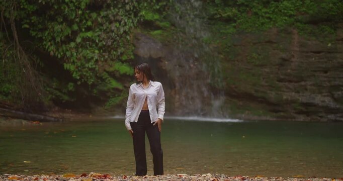 A photorealistic portrait of a young woman in a vibrant bikini standing under a cascading tropical waterfall, sunlight filtering through lush jungle ferns.