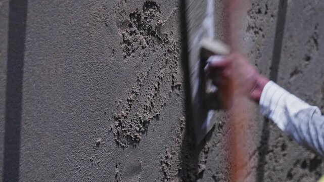 worker using trowel tool and wooden float tool for wall plastering at construction site, hyderabad, telangana, india. day time, stable shot, 4k.