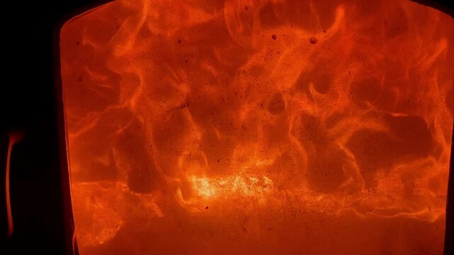 Intense orange red fireplace flames roaring with warm glow and cozy heat, close up texture evoking comfort and energy indoors