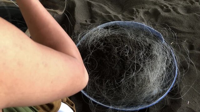 fisherman is attaching multiple hooks to a nylon fishing line.