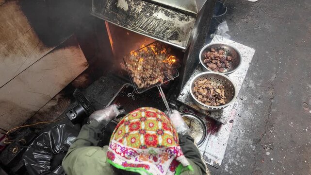 Overhead View of Street Food Vendor Grilling Meat Skewers Over Charcoal Fire