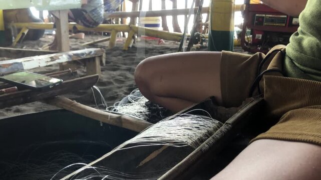 fisherman is attaching multiple hooks to a nylon fishing line.