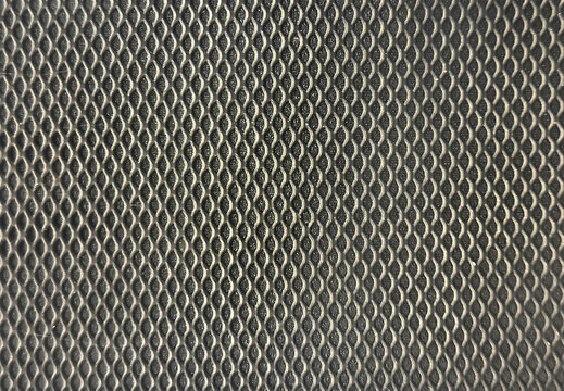 Close up of black perforated wiremesh metal with black background. Red perforated panel texture. Seamless graphic background texture.