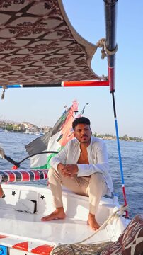 Traveler relaxing aboard a traditional felucca on the Nile River, Egypt