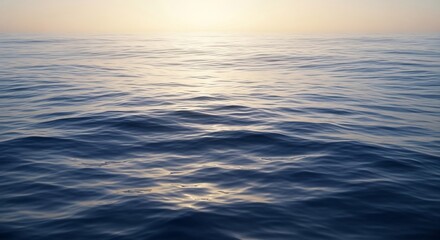 Obraz premium Serene Ocean Surface Reflecting Golden Sunlight at Dawn.