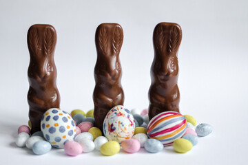 Easter holiday postcards.  Postcards for greetings, leaflets. Easter celebration 2026. White, pink, blue, yellow, green colors of Easter decorations. Ester eggs, chocolate rabbits on white, pink and d