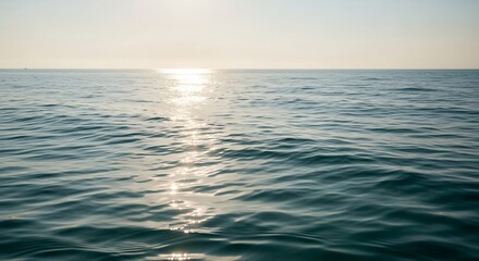 Obraz premium Calm Ocean Surface Reflecting Golden Sunlight at Dusk.