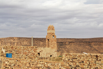 Naklejka premium The ancient mosque of the local village close old city Ouadane in Sahara desert, Mauritania