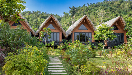 Wooden holiday bungalows blending with lush green landscape in huyn cat hi, hi phong © Alexandre Arocas