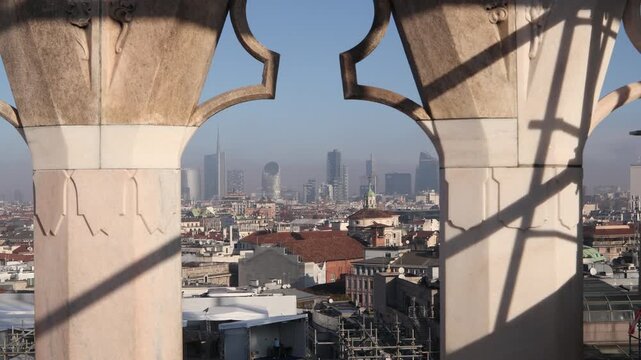 Cinematic view of Milan's modern skyscrapers seen through the intricate gothic marble carvings of the Duomo cathedral