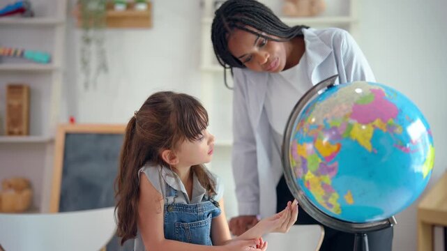 African tutor use educational globe to help a child learn about the world.